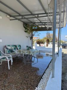 a patio with couches and a table and chairs at Anastasia's House Kos in Marmaroto