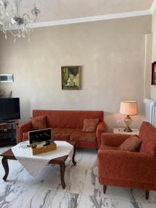 a living room with red couches and a tv at Anastasia's House Kos in Marmaroto