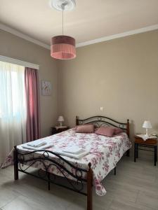 a bedroom with a bed with a pink comforter at Anastasia's House Kos in Marmaroto