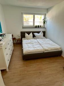 a bedroom with a bed and a dresser and a window at Cube - Ferienhaus mit Garten und Terrasse in Eberbach in Eberbach