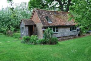 an old brick house in a field of grass at Secluded 17th Century converted barn in Midhurst