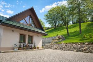 a house with a pitched roof and a gravel driveway at apartmány TASIA in Mýto pod Ďumbierom