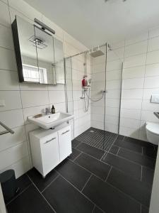 a white bathroom with a sink and a shower at Cube - Ferienhaus mit Garten und Terrasse in Eberbach in Eberbach +6 photos