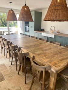 a large wooden table and chairs in a kitchen at Le Clos des Berges de l'Ain in Charnoz