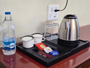 a counter with a coffee maker and a bottle of water at Kavin Uphar The Mall Road in Shimla +87 photos