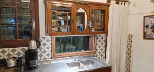 a kitchen with a sink and a wooden cabinet at Los cristales unquillo in Unquillo +27 photos