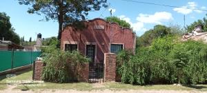 an old brick house with a fence in front of it at Los cristales unquillo in Unquillo