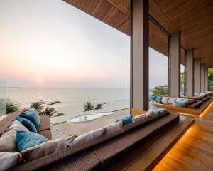 a living room with a large couch and a view of the ocean at Cape Dara Resort in North Pattaya