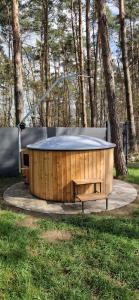 a wooden tub with a table in the grass at TomHouse in Skorochow