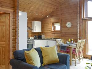 a living room with a couch and a kitchen at Seascape in Staffin