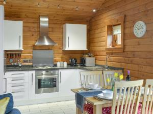 a kitchen with a stove and a table with chairs at Seascape in Staffin