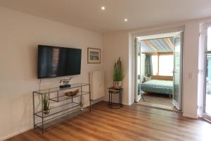 a living room with a flat screen tv on the wall at Ferienwohnung Zirbentraum in Breitbrunn am Chiemsee