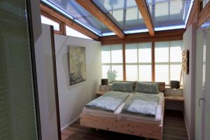 a bedroom with a bed in a room with windows at Ferienwohnung Zirbentraum in Breitbrunn am Chiemsee