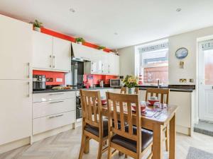 a kitchen with a table and chairs and a kitchen with white cabinets at 2 Bed in Bideford oc-73895 in Westward Ho