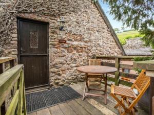a wooden table and chairs on a balcony with a building at Horner- Ukc4923 in Timberscombe