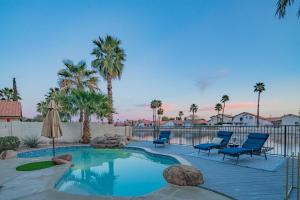 a swimming pool with chairs and a fence and palm trees at Resort-Style 5BR Heated Pool Putting Green in Glendale