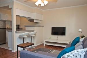 a living room with a blue couch and a kitchen at Stylish Austin Condo in Austin