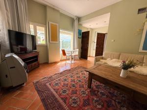 a living room with a couch and a tv at Finca las Estrellas in Relleu