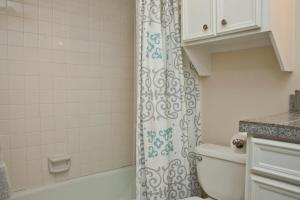 a bathroom with a shower curtain and a toilet at Stylish Austin Condo in Austin +30 photos