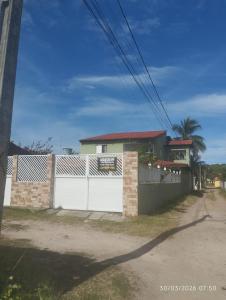 a house with a white gate and a fence at Pitimbu Beach House Rosi in Pitimbu +32 photos