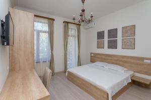 Schlafzimmer mit einem Bett, einem TV und einem Fenster in der Unterkunft Mais Guest House in Tbilisi City