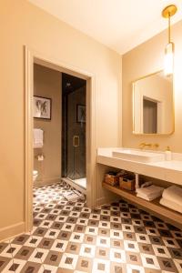 a bathroom with a sink and a mirror at Sinclair Suites - Boutique Hotel West Dundee in West Dundee