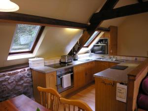 a kitchen with wooden cabinets and a stove top oven at Luccombe- Ukc4919 in Timberscombe
