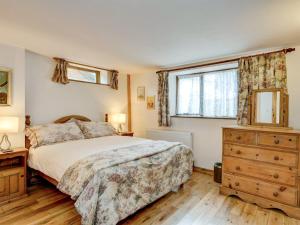 a bedroom with a bed and a dresser and a window at Luccombe- Ukc4919 in Timberscombe