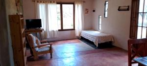 a room with a tv and a table and window at Autóctona in Villa Cura Brochero