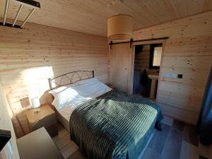a bedroom with a bed in a wooden room at The Nest - Secluded Cabin with Panoramic Views in Gurteenulla
