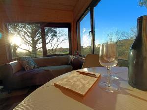 a table with a wine glass and a book on it at The Nest - Secluded Cabin with Panoramic Views in Gurteenulla