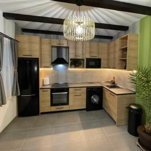 a kitchen with a black refrigerator and a chandelier at Somni Apartamente in Chinteni