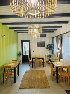 a dining room with tables and chairs and chandeliers at Somni Apartamente in Chinteni