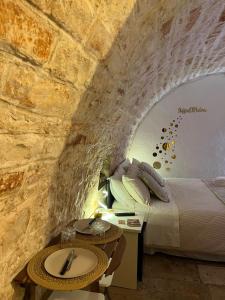 a bedroom with a bed in a stone wall at Soffio di Pietra in Castellana Grotte
