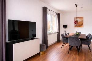 a living room with a television and a dining table at Ferienhaus Wacholder in Mechernich
