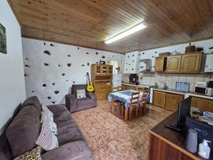 a living room with a couch and a kitchen at Casa da Queijaria in Faja Grande