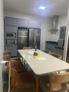 a kitchen with a white table with chairs and a refrigerator at Tecnoshow in Rio Verde