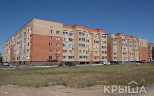 a large building with cars parked in front of it at Аэропорт-Астана двухкомнатная in Astana