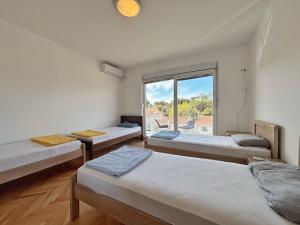 a room with four beds and a window at Vega's in Tivat