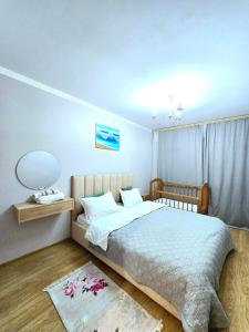 a bedroom with a bed and a table and a lamp at Аэропорт-Астана двухкомнатная in Astana