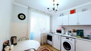 a kitchen with a washing machine and a window at Аэропорт-Астана двухкомнатная in Astana