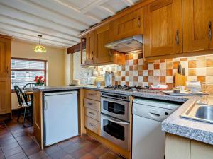 a kitchen with wooden cabinets and a stove top oven at 1 Bed in Brecon oc-bn367 in Bwlch