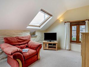 a living room with a red chair and a television at 1 Bed in Brecon oc-bn367 in Bwlch