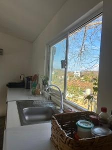a kitchen sink with a basket next to a window at Casa PuntaBlanca in Puerto Ángel