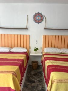 two beds sitting next to each other in a room at Casa PuntaBlanca in Puerto Ángel