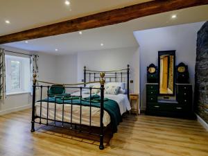 a bedroom with a bed and a dresser and a mirror at 3 Bed in Brecon oc-93680 in Llandefalle