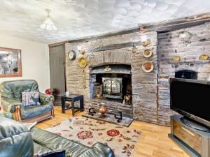 a living room with a stone wall with a fireplace at 2 Bed in Brecon oc-bn138 in Bwlch