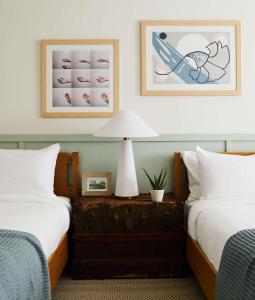 a bedroom with two beds and a table with a lamp at Wayfinder Newport in Newport