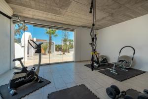 a gym with two treadmills and two exercise bikes at Maistros Village Santorini - Anamar Collection in Karterados
