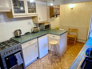 a kitchen with a stove and a counter top at Butterfly Cottage in Knowle